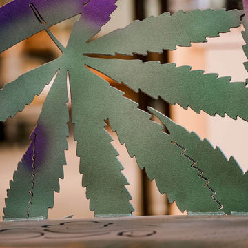 Close up of cannabis leaf on metal garden bench